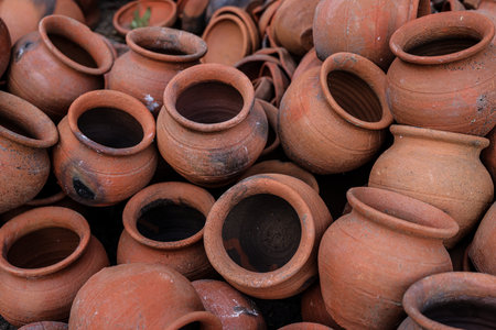 pots are gathered and arranged in a pattern in the empty space. The potter works on a pottery wheel...