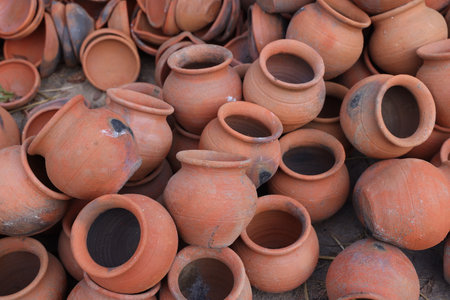 pots are gathered and arranged in a pattern in the empty space. The potter works on a pottery wheel...