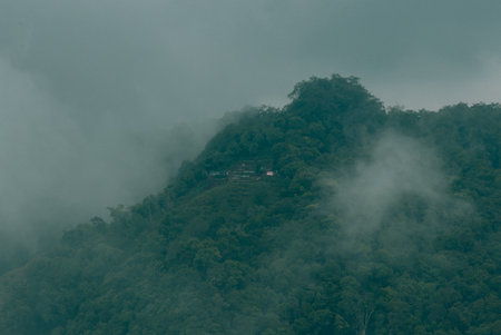 Misty clouds passing on top of the mountains or hills. Greenery mountains on the foggy morning