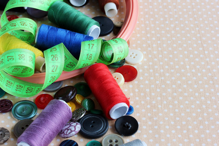 Objects for needlework and sewing: different buttons, colored threads, hoops and tape for measuring...