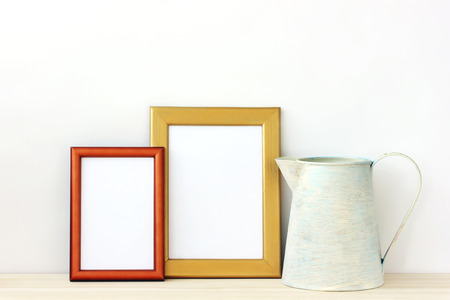 Empty gold photo frames and pitcher. Background, layout for installation of Your text or image.