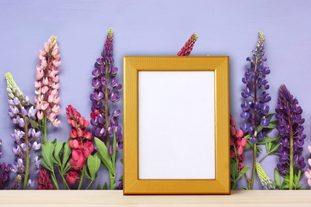 Empty gold frame for photo on backdrop of flowers. mockup, empty space for your text or image. Texture.の写真素材