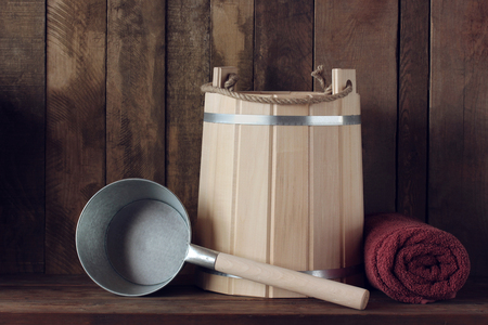 interior of the bath or sauna: shelf in the steam room with bath amenities. Bucket of slats,  large towel and  tin bucket.の写真素材