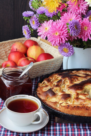 Tea and Apple pie Charlotte. Food still life. Cake, drink, flowers and apples on the table.の写真素材