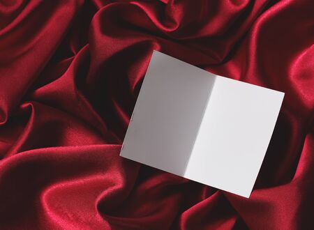 empty open postcard on Burgundy satin or silk fabric, top view. luxury material with wave folds for the background. layout, template, copy space.の写真素材
