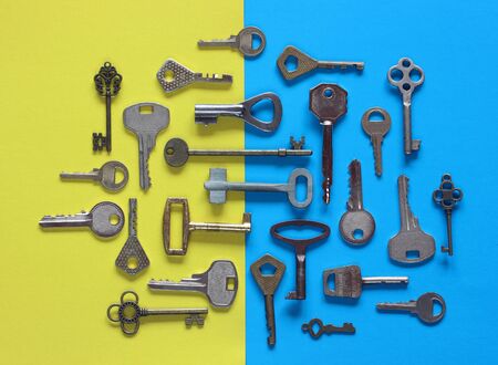 various metal keys on a blue-yellow background, top view. flat lay.