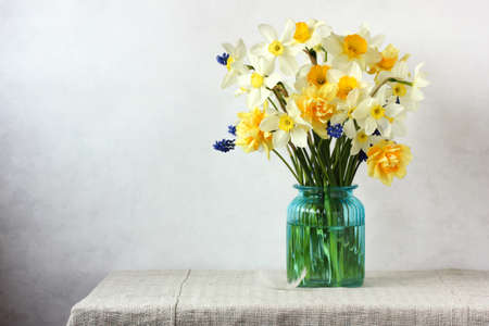 bouquet of yellow daffodils in a glass vase on a table.