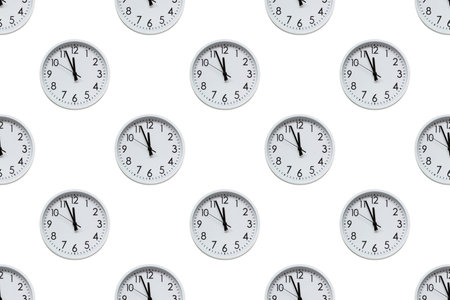 Many identical white clocks are displayed on a seamless white background, creating a uniform and timeless patternの写真素材