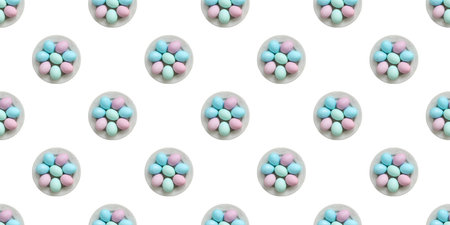 Colorful easter eggs arranged on white plates, creating a repeating pattern against a clean white backdropの写真素材