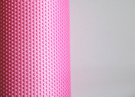 Close-up of pink foam roller highlights its textured surface, ideal for fitness, recovery, and self-care themesの写真素材