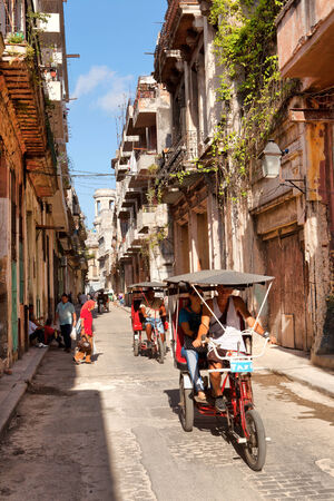 HAVANA - MAY 15: The urban cityscape, pedicab on the road on May 15, 2013 in Havana, Cubaのeditorial素材