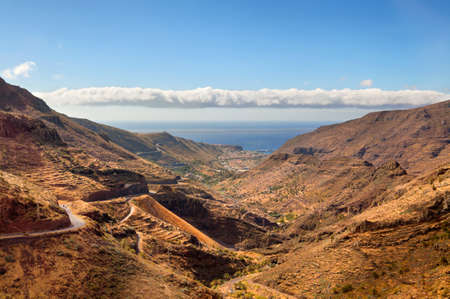 scenic landscape of mountain valley with blue sky, white clouds and colorful houses (Tenerife, Canary islands, Spain)の写真素材
