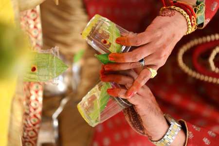 at indian marriage event performing pooja with waterの写真素材