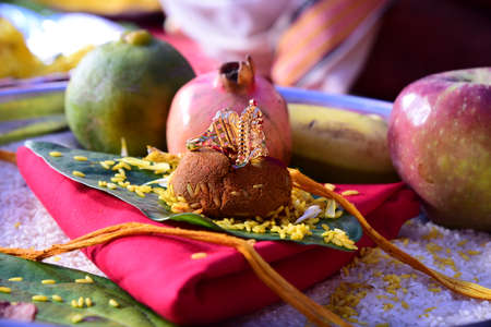 Plate full of fruits along with gold ring on green leafの写真素材