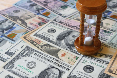 Hourglass and dollars. Concept - time is money.