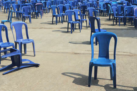 Chaotically standing blue plastic chairs. The concert is over, people are gone.の写真素材