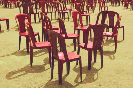 Red chairs on yellow, stand chaotically scattered.の写真素材