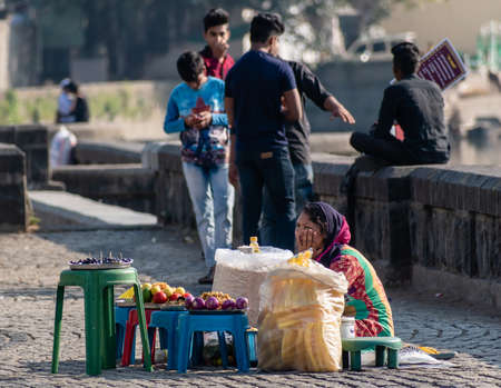 Nagpur, Maharahstra, India - March 2019: An Indian woman selling street snacks by the Futala lake in the city.のeditorial素材