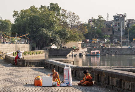 Nagpur, Maharahstra, India - March 2019: Indian women selling snacks on the promenade by the Futala lake in the city.のeditorial素材