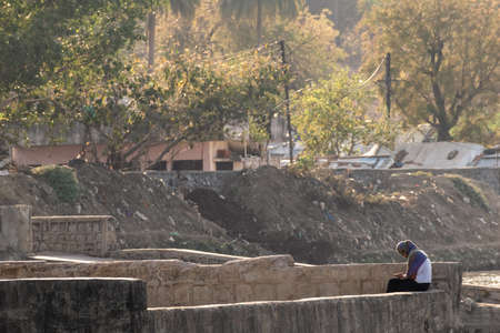 Nagpur, Maharahstra, India - March 2019: A young Indian girl wearing a veil sitting alone at the...