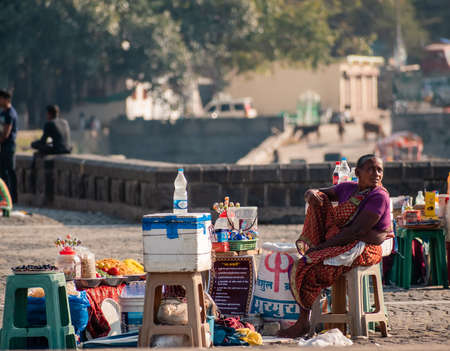 Nagpur, Maharahstra, India - March 2019: An Indian woman selling street snacks by the tourist site of the Futala lake in the city.のeditorial素材