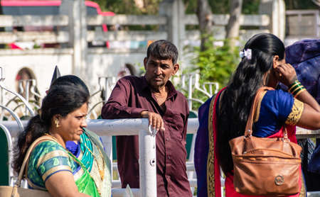 Nagpur, Maharashtra, India - March 2019: A candid portrait of a mid adult Indian man standing by a crowded market street and watch people go by.のeditorial素材