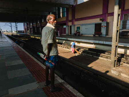 Chennai, Tamil Nadu, India - January 2020: An elderly Indian man waiting for a train at the  Thiruvanmiyur MRTS station.のeditorial素材