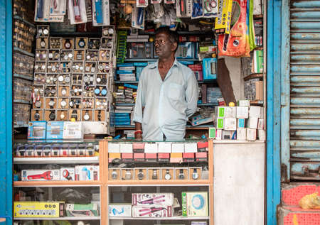 Chennai, Tamil Nadu, India - August 2018: An Indian shopkeeper inside a shop that sells wristwatches and stationery.のeditorial素材