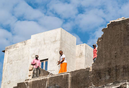 Somnath, Gujarat, India - December 2018:  Three Indian men working on the plumbing on a rooftop of a house.のeditorial素材
