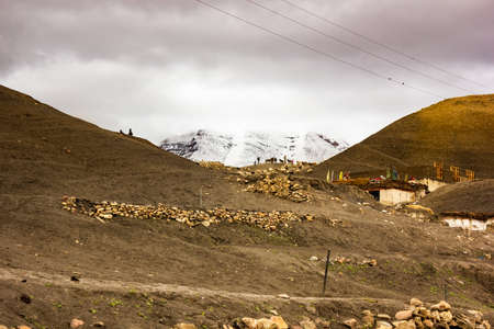 Langza, Himachal Pradesh, India - May 2012:  A beautiful bucolic scene of the Himalayan village with snow capped mountains on an overcast day.の写真素材