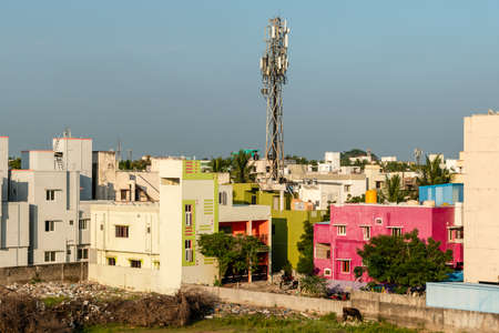 Chennai, Tamil Nadu, India - January 2020: A telecommunications tower rises above a low rise...