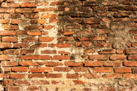 Red brick wall background with uneven masonry