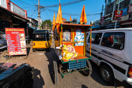 Trichy, Tamil Nadu, India - February 2020: A mobile shrine to Hindu Gods  with saffron prayer flags in the traffic on the streets of the city of Tiruchirappalli.のeditorial素材