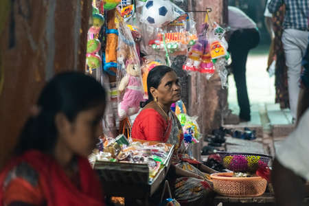 Mayiladuthurai,  Tamil Nadu, India - February 2020: An Indian woman street vendor sitting in a market with a thoughtful expression on her face.のeditorial素材
