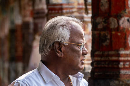 Mayiladuthurai,  Tamil Nadu, India - February 2020: A candid portrait of an elderly Indian man with a thoughtful expression inside the ancient temple of Vaitheeswaran Koil.のeditorial素材