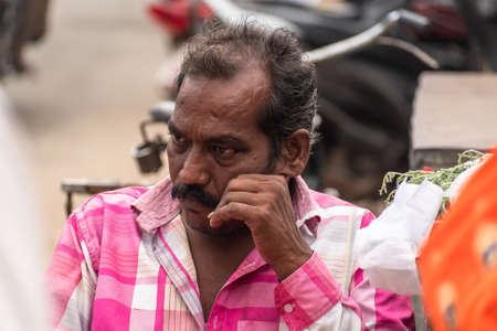 Mayiladuthurai, Tamil Nadu, India - February 2020: Candid portrait of a middle aged Indian man lost in thought on the streets of a city.のeditorial素材