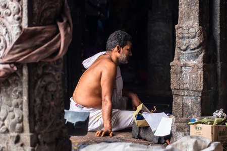 Mayiladuthurai, Tamil Nadu, India - February 2020: A bare bodied Hindu priest dressed in traditional attire inside the ancient temple at Vaitheeswaran Koil.のeditorial素材