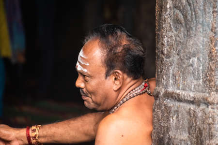 Mayiladuthurai, Tamil Nadu, India - February 2020: A candid portrait of a Hindu priest with holy ash smeared on the forehead inside the ancient temple at Vaitheeswaran Koil.のeditorial素材