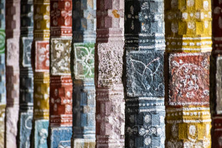 Mayiladuthurai, Tamil Nadu, India - February 2020: Colourfully painted pillars with intricate carvings inside the ancient Hindu temple at Vaitheeswaran Koil. Selective focus on one pillar.のeditorial素材