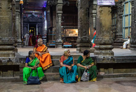 Kumbakonam, Tamil Nadu, India - February 2020: Elderly Indian women sitting on the steps beside the stone pillars of the ancient Hindu temple of Swamimalai.のeditorial素材