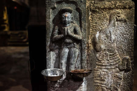 Ancient carvings of a Hindu deity beside an elephant on the stone walls of a Hindu temple in Kumbakonam.のeditorial素材