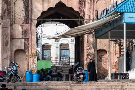 Bhopal, Madhya Pradesh,India - March 2019: An Indian woman wearing a black burkha walks in front of...