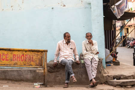 Bhopal, Madhya Pradesh,India - March 2019: Two elderly Indian men sitting on a stone bench on a street in the old city of Bhopal.のeditorial素材