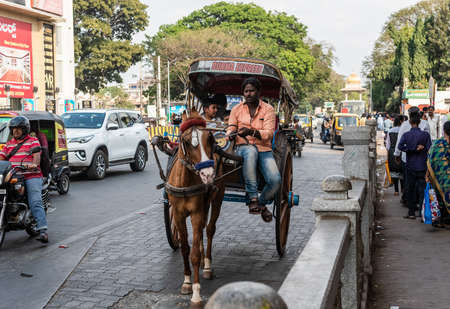 Mysuru, Karnataka, India - January 2019: A man riding a horse cart on the streets of the city of...