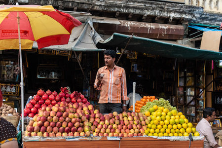 Mysuru, Karnataka, India - January 2019: An Indian street vendor selling fruits at his stall in the Devaraj market in the city of Mysuru.のeditorial素材