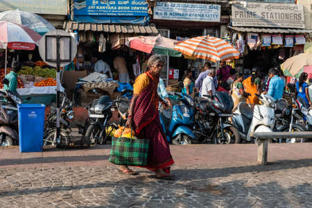 Mysuru, Karnataka, India - January 2019: An Indian woman walking in a crowded market street in the city of Mysore.のeditorial素材
