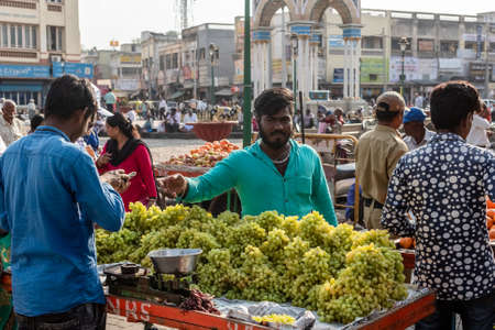 Mysuru, Karnataka, India - January 2019: A street vendor selling fresh green grapes at his fruit stall on the streets of the city of Mysore.のeditorial素材