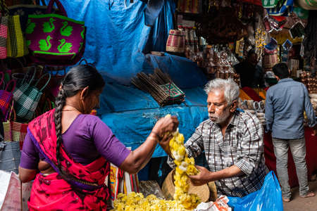 Mysuru, Karnataka, India - January 2019: An elderly Indian man selling flowers in a market square in the city of Mysore.のeditorial素材