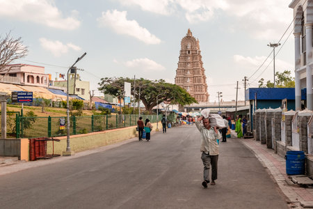 Mysuru, Karnataka, India - January 2019: An Indian labourer walking on a street leading to the ancient Hindu temple of Chamundeshwari at the Chamunda Hills near Mysore.のeditorial素材