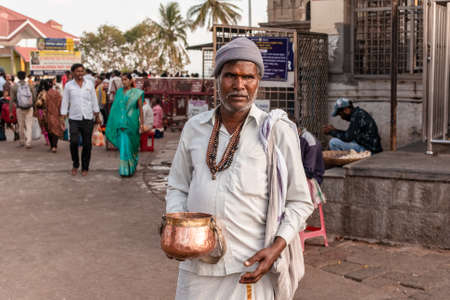 Mysuru, Karnataka, India - January 2019: An Indian man in traditional attire begging for alms at the ancient Hindu pilgrimage site of Chamundi Hills.のeditorial素材